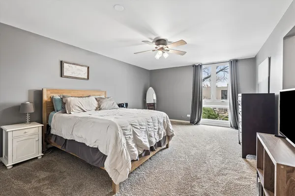 a spacious bedroom with a bed and a flat screen tv