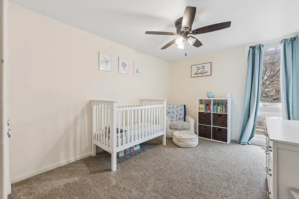 a living room with a baby crib furniture and a window