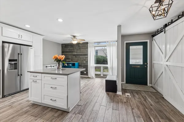 a kitchen with a refrigerator and wooden floors