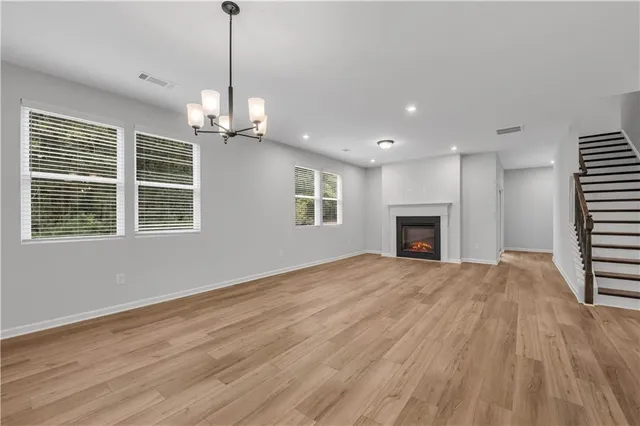 a view of empty room with wooden floor and fireplace