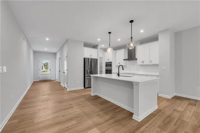 a view of large kitchen with stainless steel appliances granite countertop a sink and wooden floor