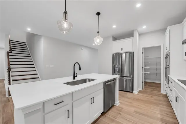 a kitchen with stainless steel appliances a sink stove and refrigerator