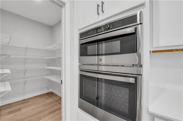 a kitchen with granite countertop white cabinets and stainless steel appliances