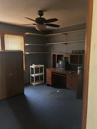 a view of an empty room with a fireplace and a window