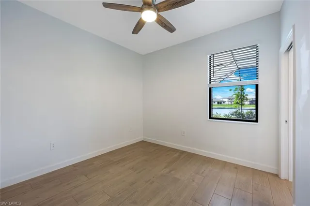 an empty room with a window and a ceiling fan