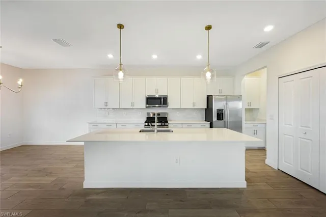 a view of kitchen with stainless steel appliances granite countertop cabinets and wooden floor