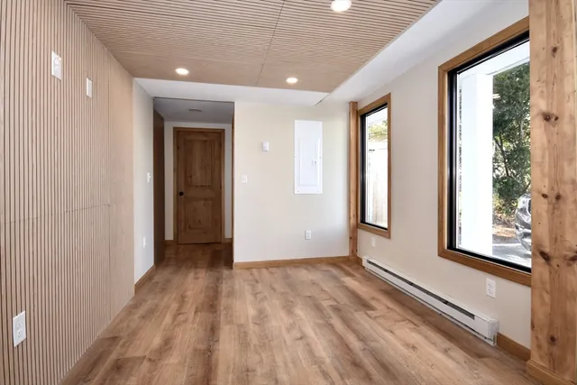 a view of hallway with windows and wooden floor