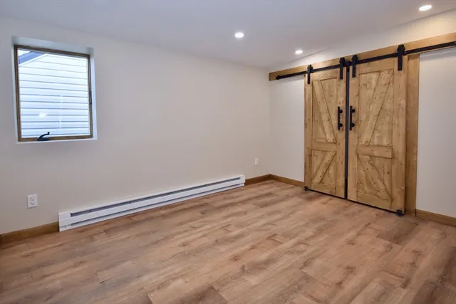 an empty room with wooden floor and glass door
