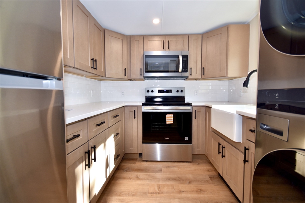 130 Swindells Street, Unit 2 Fall River, MA 02723 - Photo 5 of 7 a kitchen with stainless steel appliances granite countertop a stove a sink and a refrigerator