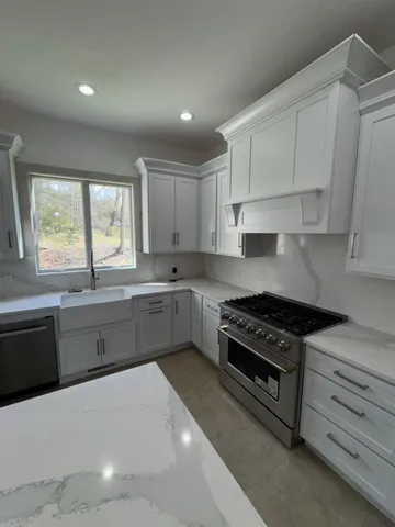 a kitchen with stainless steel appliances a stove a sink and cabinets