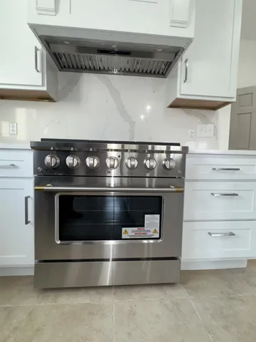 a stove top oven sitting inside of a kitchen