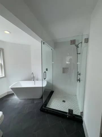 a bathroom with a toilet a sink and mirror