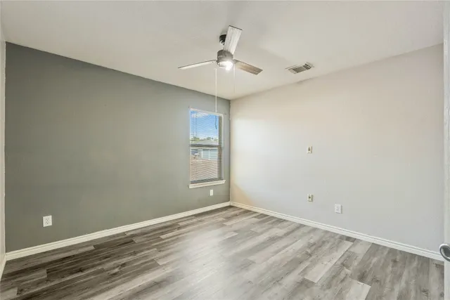 a view of room with hardwood floor and ceiling fan