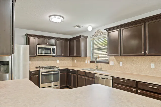 a kitchen with stainless steel appliances granite countertop a refrigerator stove and sink