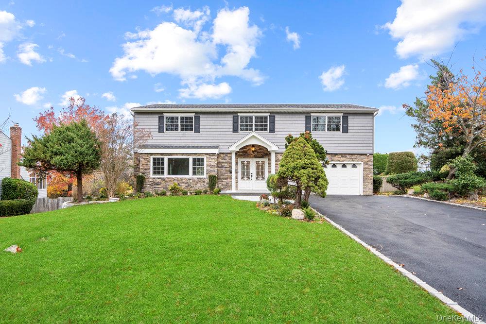 52 Woodland Road Roslyn, NY 11576 - Photo 2 of 23 a front view of a house with garden