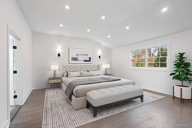a bedroom with a large bed and a potted plant