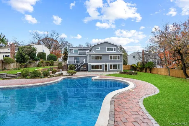 a view of a swimming pool in front of the house
