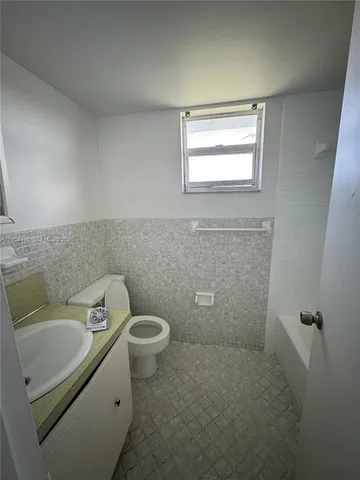 a bathroom with a toilet sink and window
