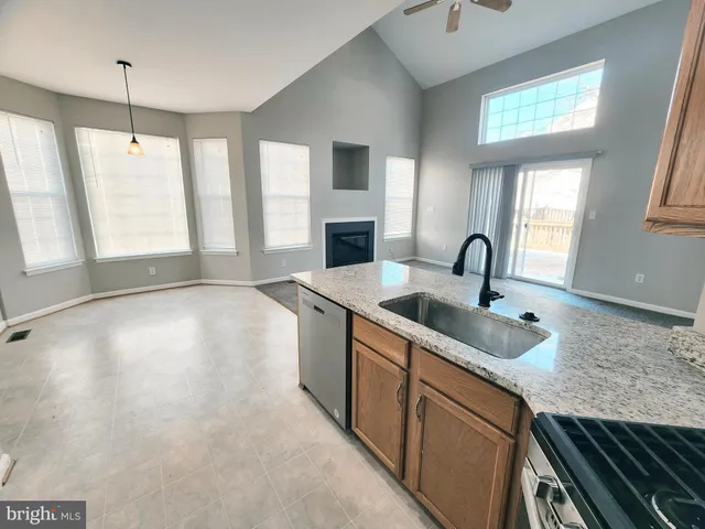 a kitchen with stainless steel appliances granite countertop a sink a stove and a wooden floors
