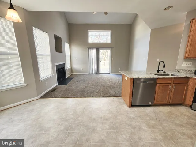 a view of a kitchen with a sink dishwasher and a fireplace