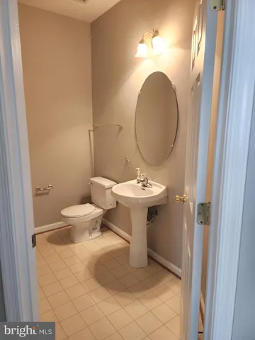 a bathroom with a sink toilet and a mirror