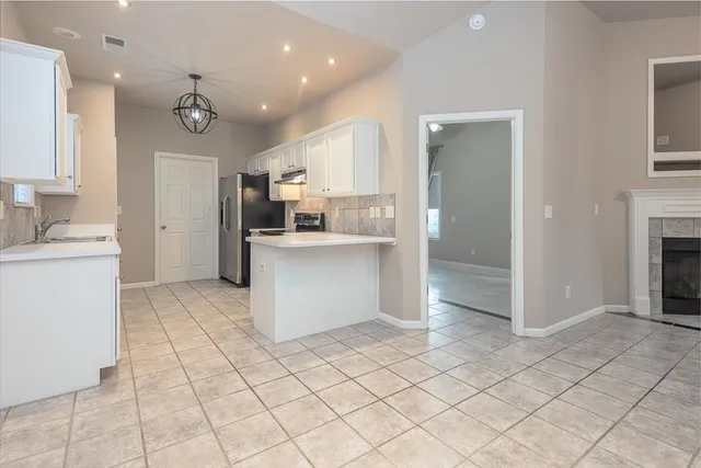 a kitchen with stainless steel appliances kitchen island granite countertop a refrigerator and a sink