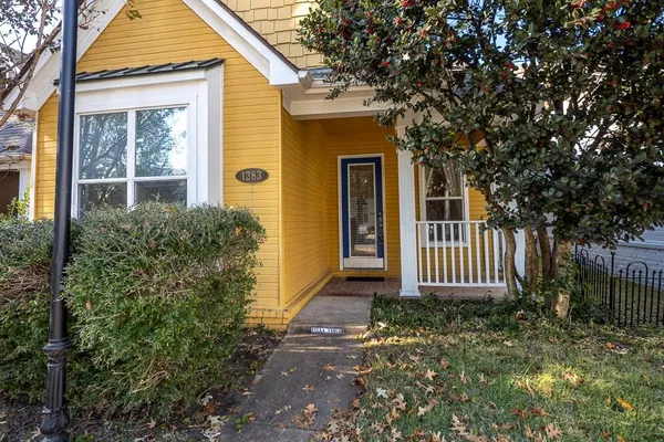 an empty room with wooden floor closet and windows