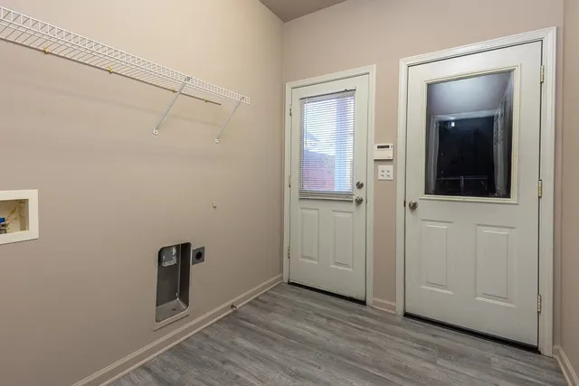 an empty room with wooden floor closet and windows