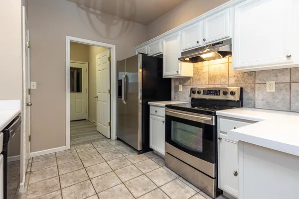 a kitchen with stainless steel appliances granite countertop a stove a refrigerator and a cabinets