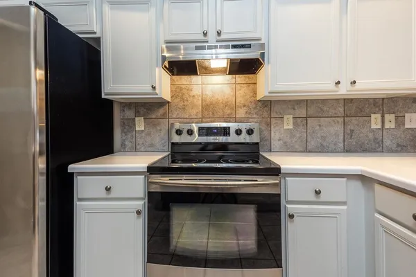 a stove top oven sitting inside of a kitchen
