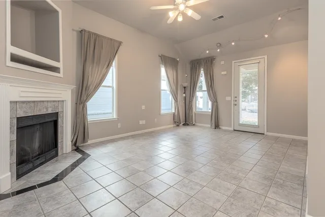 a view of an empty room with a fireplace and a window