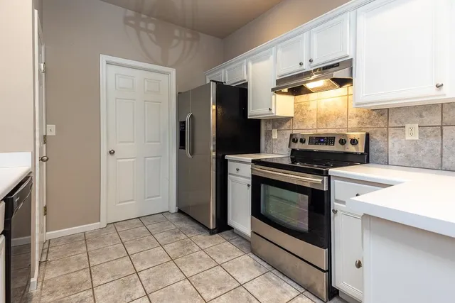 a kitchen with stainless steel appliances granite countertop a stove a refrigerator and a cabinets