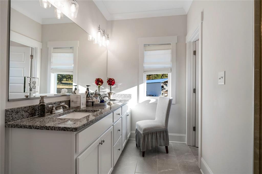 564 Old Airport Road Commerce, GA 30530 - Photo 27 of 39 a en suite bathroom with a granite countertop sink and a mirror