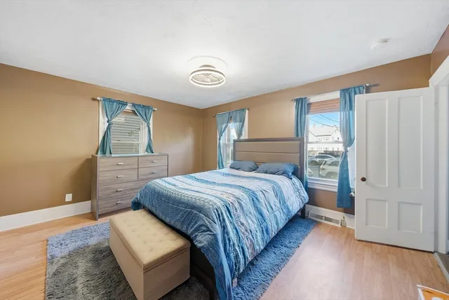 a bedroom with a bed and wooden floor