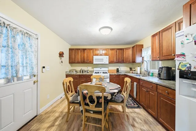 a kitchen with stainless steel appliances granite countertop a table chairs microwave and sink