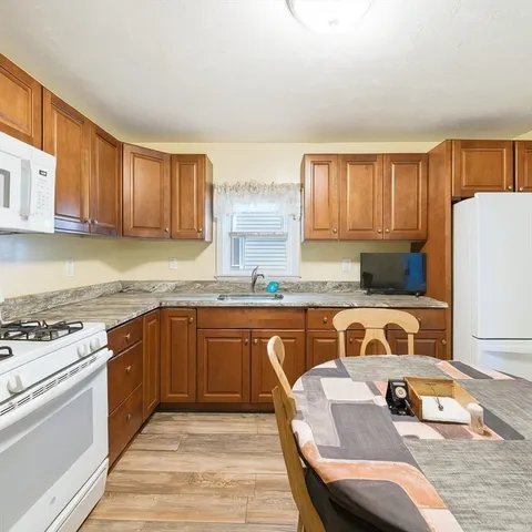 a kitchen with granite countertop a sink stove and cabinets