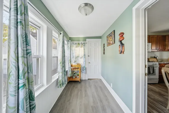 a view of hallway with livingroom and wooden floor