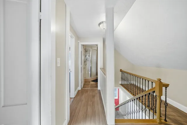 a view of a hallway with wooden floor and staircase