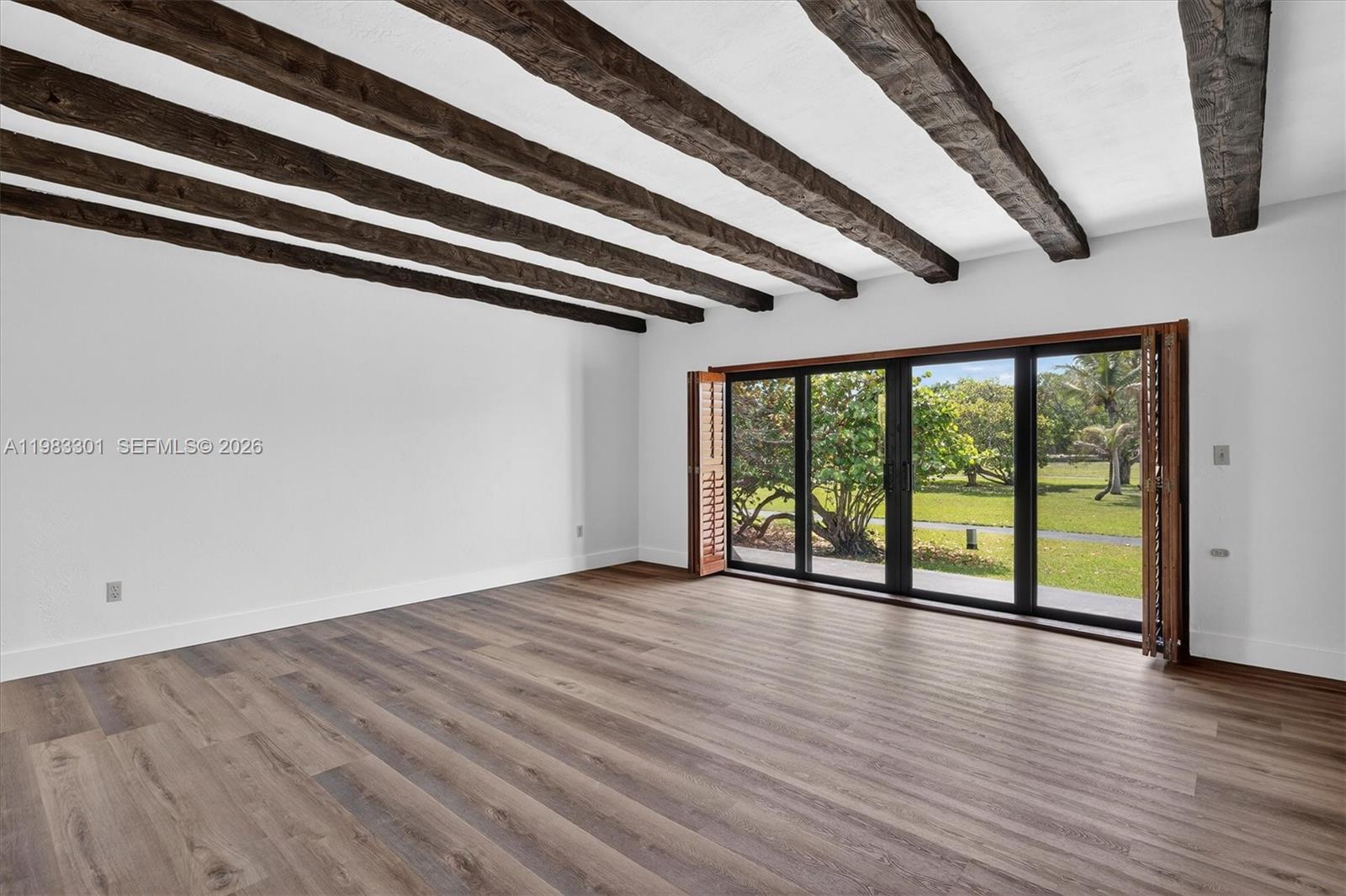 6190 Southwest 90th Court, Unit 1K Miami, FL 33173 - Photo 18 of 49 an empty room with wooden floor and windows