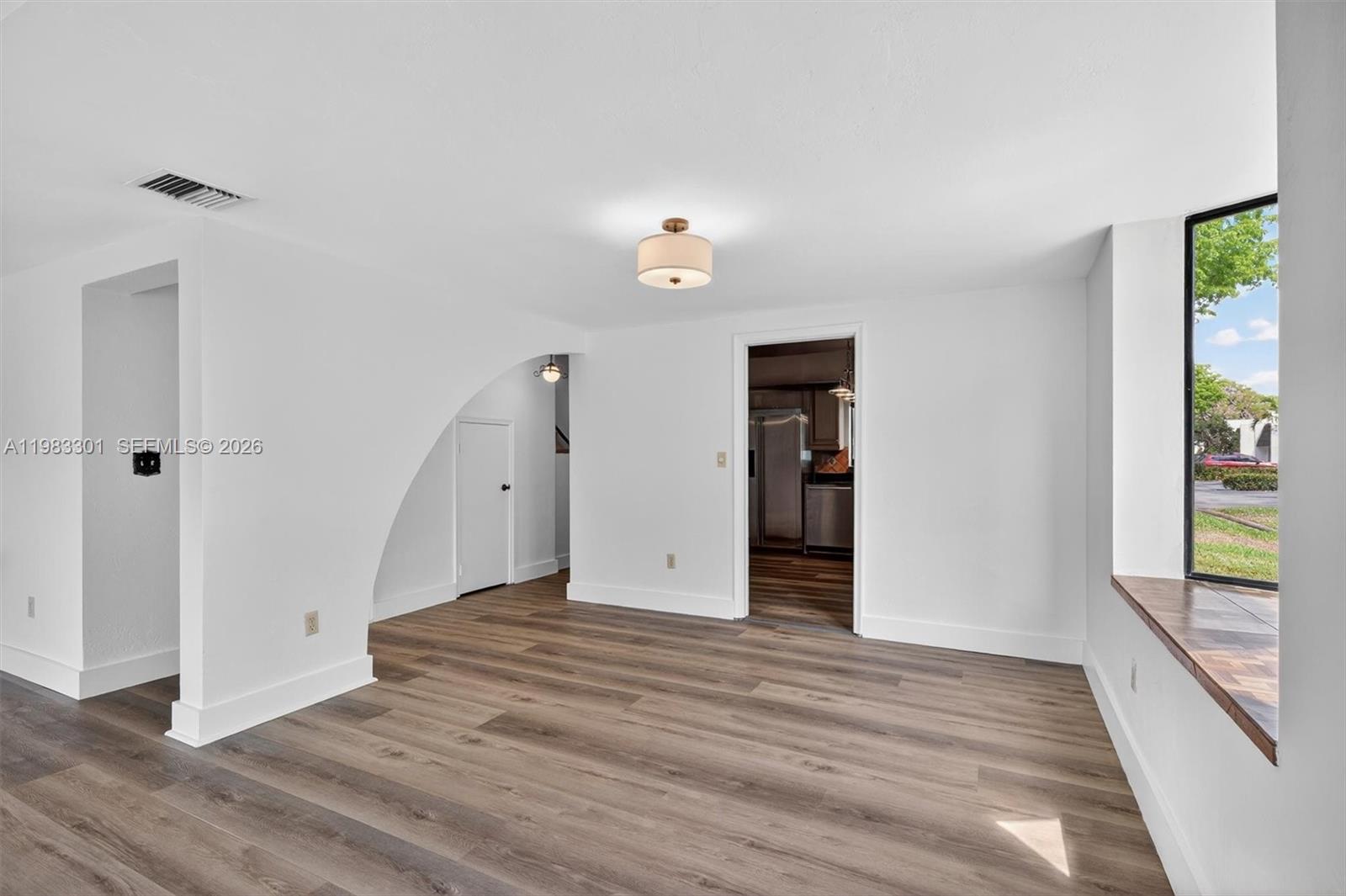 6190 Southwest 90th Court, Unit 1K Miami, FL 33173 - Photo 19 of 49 a view of an empty room with wooden floor and a window