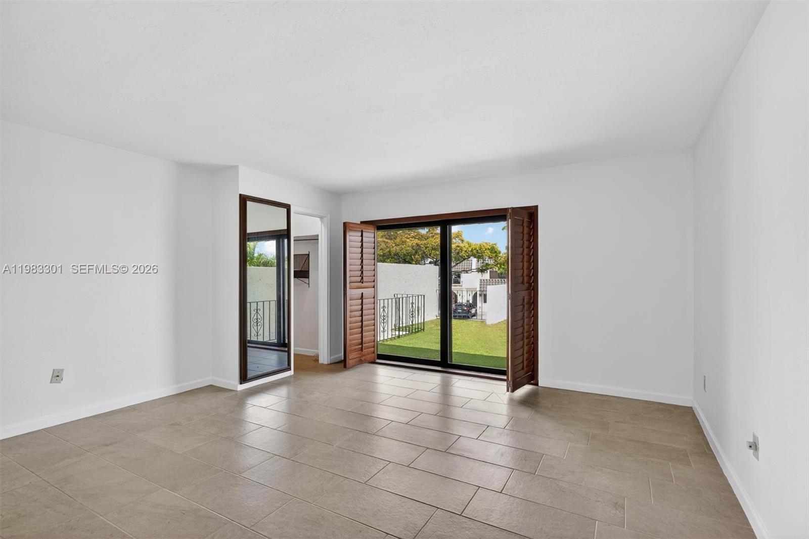 6190 Southwest 90th Court, Unit 1K Miami, FL 33173 - Photo 24 of 49 a view of an empty room with glass door