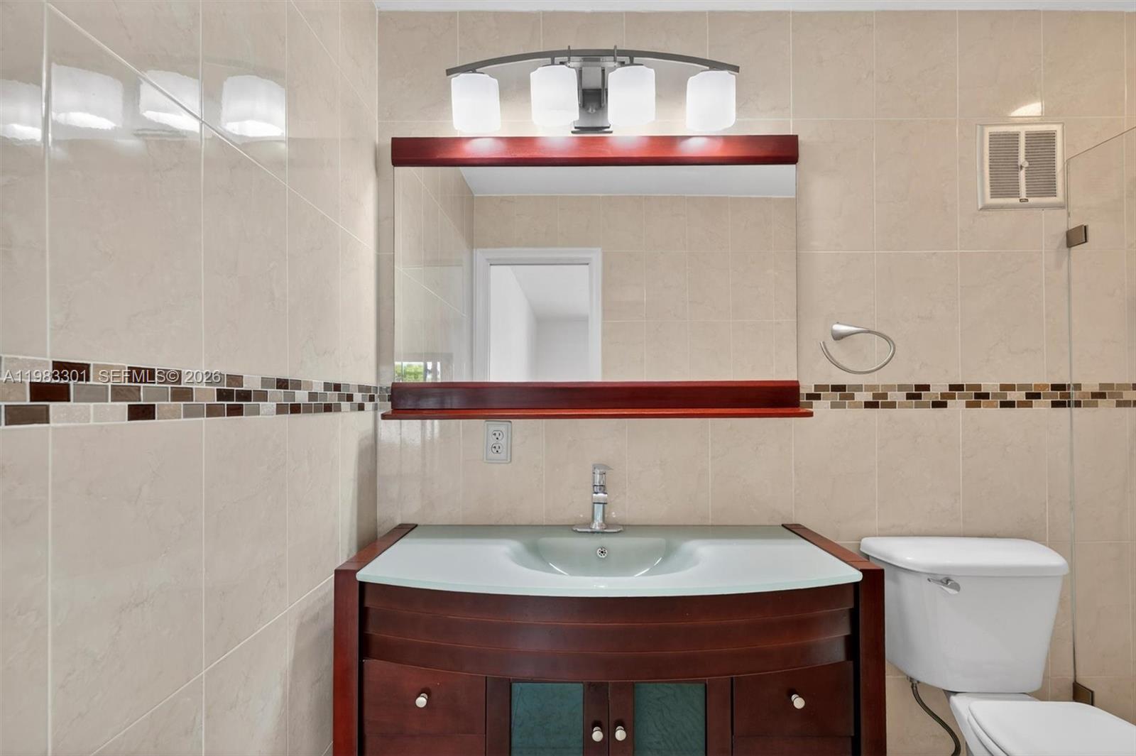 6190 Southwest 90th Court, Unit 1K Miami, FL 33173 - Photo 29 of 49 a bathroom with a sink and a mirror