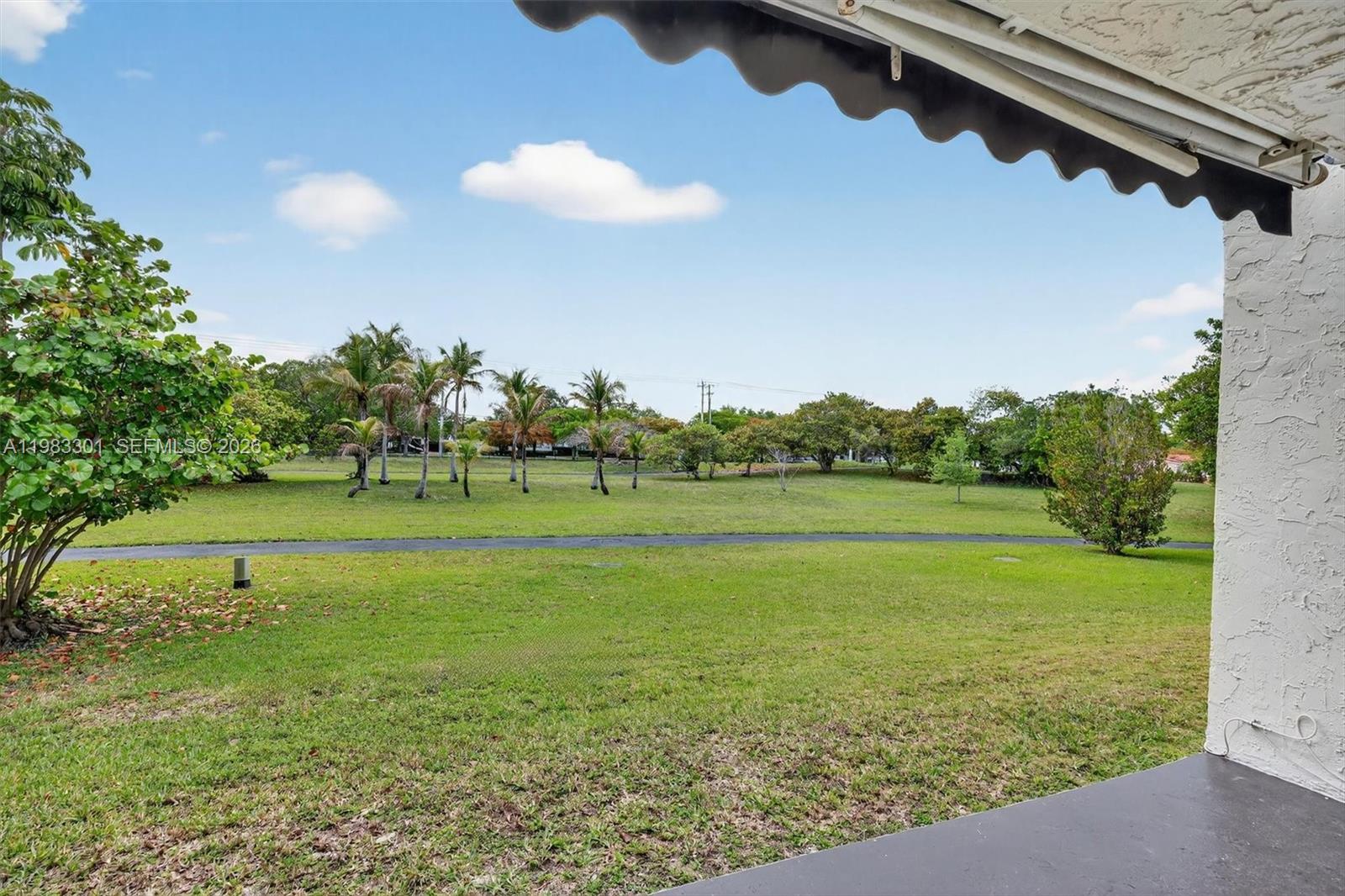6190 Southwest 90th Court, Unit 1K Miami, FL 33173 - Photo 36 of 49 a view of a field with an trees in the background