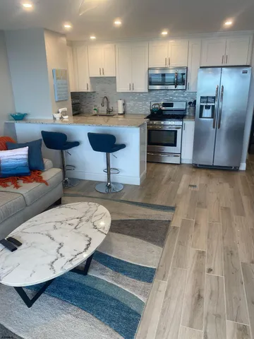 a kitchen with stainless steel appliances granite countertop a sink dishwasher stove top oven and refrigerator