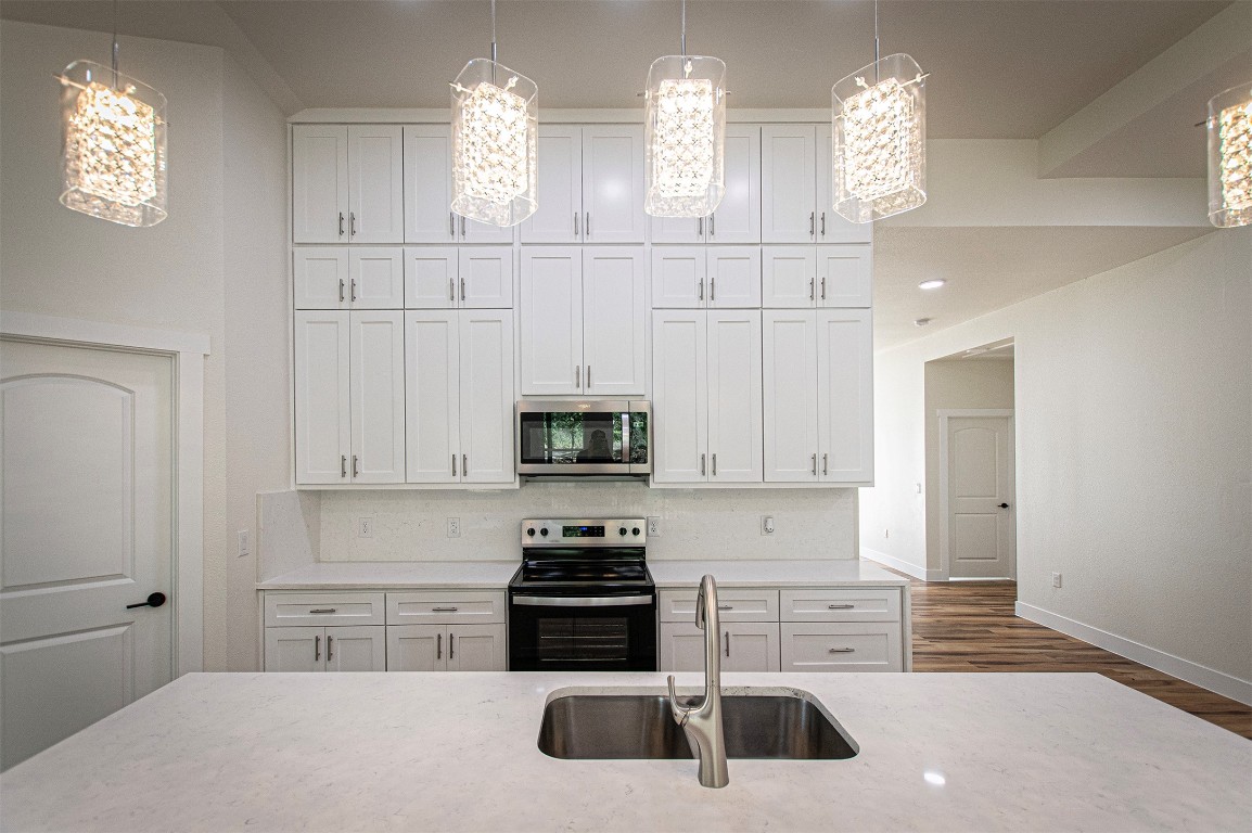 106 Passion Vine Rd Dale Dale, TX 78616 - Photo 5 of 23 a kitchen with white cabinets and appliances