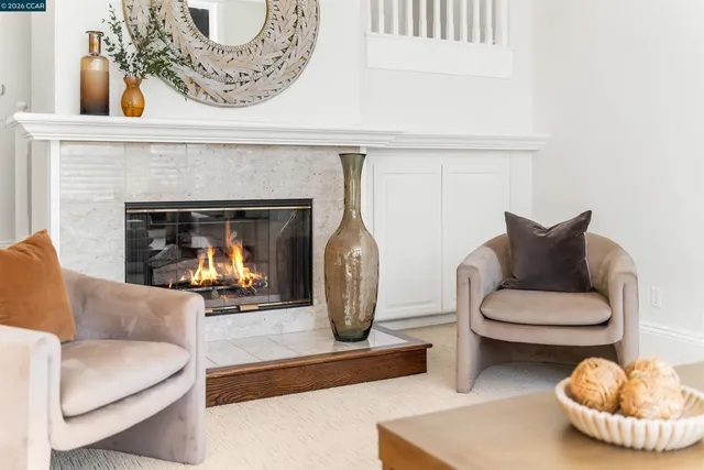 a living room with furniture a fireplace and a chandelier