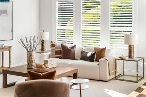 a living room with furniture a fireplace and a large window