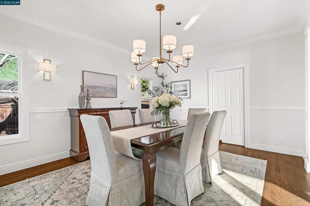 a kitchen with stainless steel appliances a table chairs in it and wooden floor