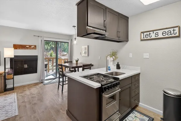 a kitchen with stainless steel appliances granite countertop a stove and a wooden cabinets
