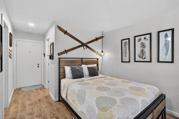 a bedroom with a bed and painting on the wall